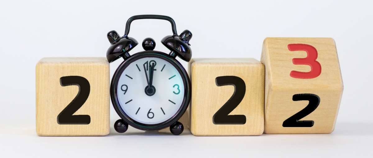 clock about to strike midnight and the numbers 2022 rolling over into 2023